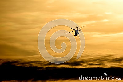 Helicopter Flying at Sunset Stock Photo