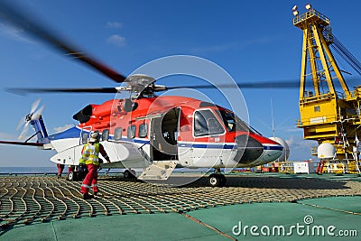 The helicopter landing officer is going to helicopter at oil rig Stock Photo