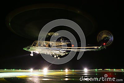 Helicopter landing in offshore oil and gas platform on deck or parking area. Helicopter night flight training of pilot Stock Photo