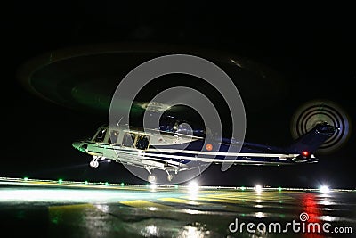 Helicopter landing in offshore oil and gas platform on deck or parking area. Helicopter night flight training of pilot Stock Photo