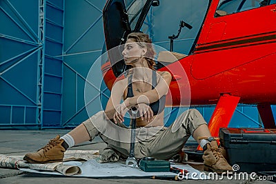 Helicopter maintenance femail worker. woman pilot or helicopter mechanic holding the adjustable wrench. Stock Photo