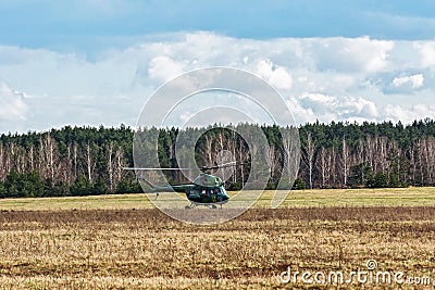 The helicopter MI-2 landed on the field near the forest belt Editorial Stock Photo