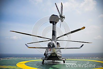 Helicopter parking on helideck and waiting passenger. Helicopter landing and waiting for ground service. Stock Photo
