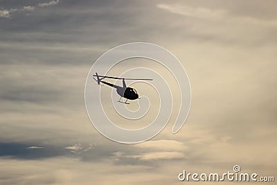 Helicopter silhouette against clouds Stock Photo