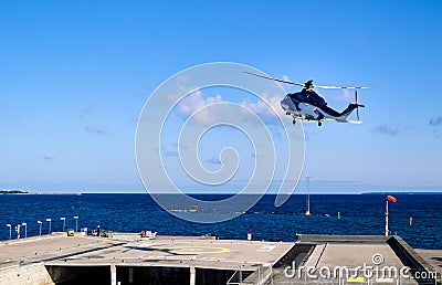 Helicopter starting from helipad By Tallinn - Baltic sea Stock Photo