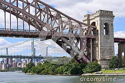 The Hell Gate Bridge seen from the East River with the RFK Bridge and the skyline of Manhattan behind Editorial Stock Photo