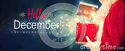 Hello December message with Santa opening a gift box Stock Photo