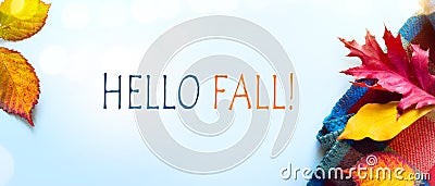 Hello fall message with Autumn leaves and Warm scarf on a blue background Stock Photo