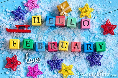 Hello February written on colour wooden toy cubes On light background with snow Stock Photo