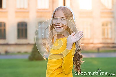Hello gorgeous. Happy child wave hand outdoors. Little child smile in casual style. Small child wear long wavy hair Stock Photo