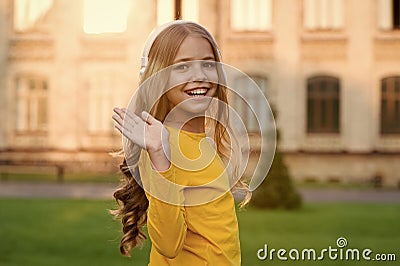 Hello gorgeous. Happy child wave hand outdoors. Little child smile in casual style. Small child wear long wavy hair Stock Photo