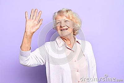 Hello Happy stylish old woman raising her hand Stock Photo