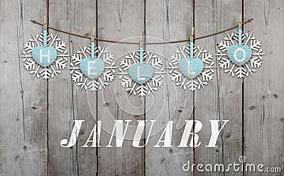 Hello january written on hanging ice blue hearts and white wooden snowflakes Stock Photo