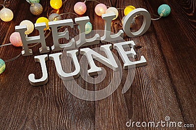 Hello June alphabet letters with LED cotton balls decoration on wooden background Stock Photo