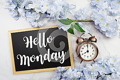 Hello Monday text on wooden blackboard and flower decoration on marble background Stock Photo