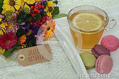 Hello October text on label, autumn flowers and cup of tea Stock Photo
