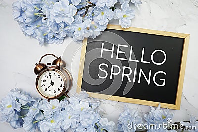 Hello Spring text on wooden blackboard and flower decoration on marble background Stock Photo