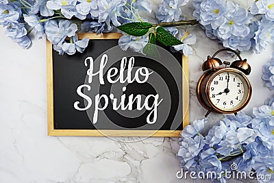 Hello Spring text on wooden blackboard and flower decoration on marble background Stock Photo