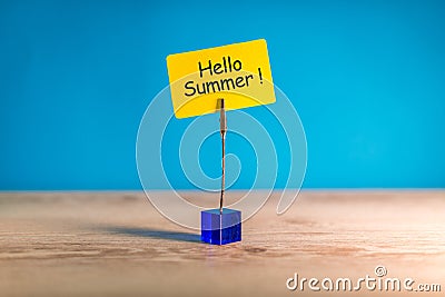 Hello Summer - text on a little yellow tag on blue bright background. First summer day. Happy Childrens Day Stock Photo