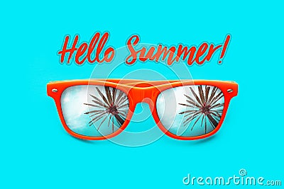 Hello Summer text Orange sunglasses with palm tree reflections isolated in intense cyan background. Minimal image concept. Stock Photo