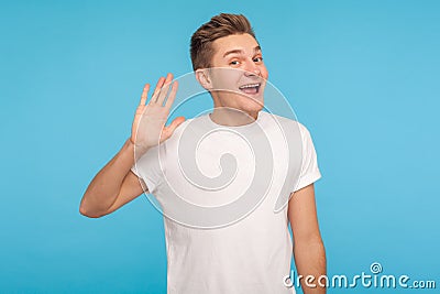 Hello, welcome! Portrait of funny happy hospitable man in casual white t-shirt waving hand Stock Photo