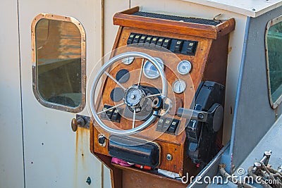 Helm of a boat, vintage wooden navigation panel with steering wheel Stock Photo