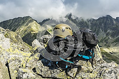 Helmet in color dark khaki and black backpack tourists in the mountains. Stock Photo