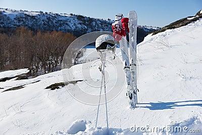 Helmet and Goggles with Skis and Poles on Hillside Stock Photo