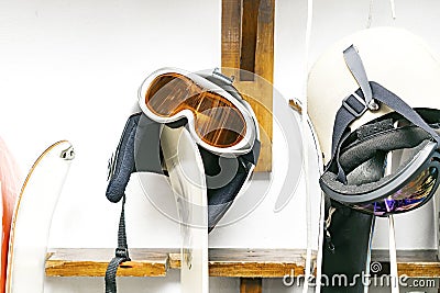 Helmet, ski mask, ski on customized wall mount at warehouse. Extreme winter sport equipment Stock Photo