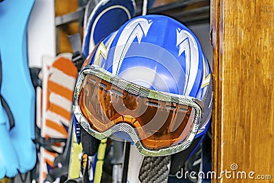 Helmet, ski mask, ski on customized wall mount at warehouse. Extreme winter sport equipment Stock Photo