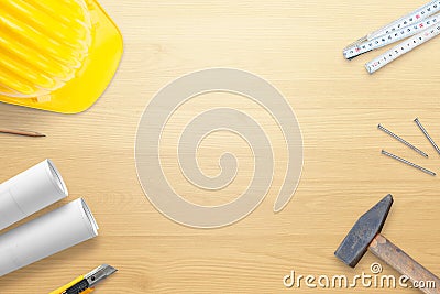 Helmet, tools and plans on wooden work desk. Copy space in the middle Stock Photo