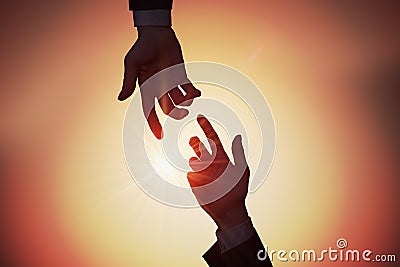 Help and assistance concept. Two hands are reaching each other at sunset Stock Photo