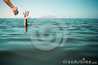 Help hand for drowning man life saving in sea or ocean. Stock Photo