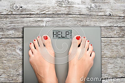 Help to lose kilograms with woman feet stepping on a weight scale Stock Photo