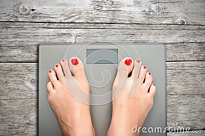 Help to lose kilograms with woman feet stepping on a weight scale Stock Photo