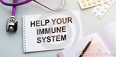 Help your immune system write on a medical notebook. Background on the table with a stethoscope and pills. medicine and health Stock Photo