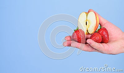 Help yourself. Fresh harvest of ripe fruit berries. Hand proposes take strawberry and apple fruit. Male hand with Stock Photo