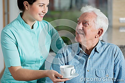 Helper giving cup of coffee Stock Photo