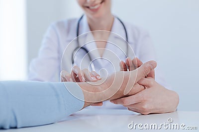 Helpful practitioner checking patient pulse in the clinic Stock Photo