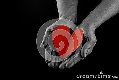 Helping hand concept, Man`s hands palms up holding a Red Heart, giving love, care and support, reaching out. side view Stock Photo