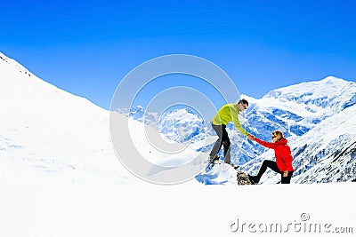 Helping hand couple hikers in mountains Stock Photo