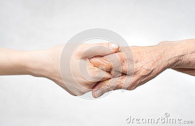 Helping hand for the elderly concept with young hand holding old hand Stock Photo