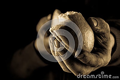 Helping hand giving a piece of bread. Poor Man sharing Bread, Helping Hand Concept. Amber close up Stock Photo