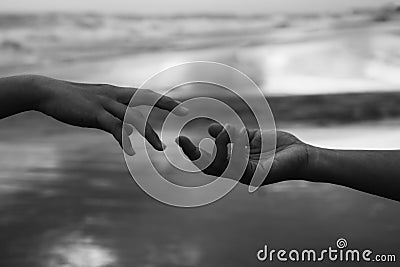 Helping hands abstract art in black and white background. Hands of two people reaching out each other. Hope, kindness and humanity Stock Photo