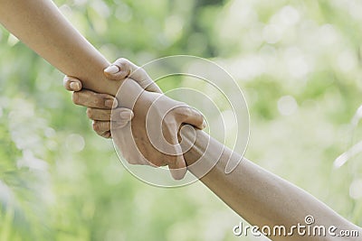 Helping hands concept. Hand holding for help on nature background Stock Photo