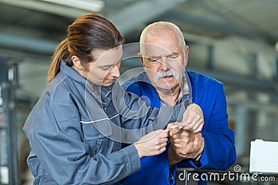 Helping senior colleague with finger accident Stock Photo