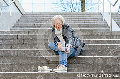 Helpless senior woman massaging her Foot Stock Photo