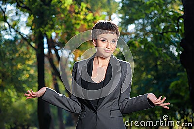 Helpless young business woman shrugs her shoulders Stock Photo