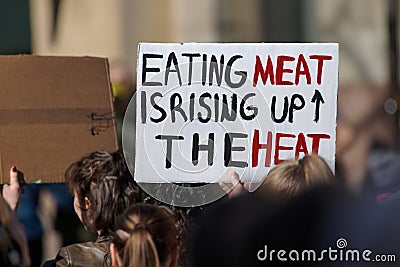 Demonstrator carrying sign Eating meat is rising up the heat Editorial Stock Photo