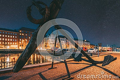 Helsinki, Finland. Old Anchor On Pier With View Of Pohjoisranta Street In Evening Night Illuminations. Colourful Night Editorial Stock Photo